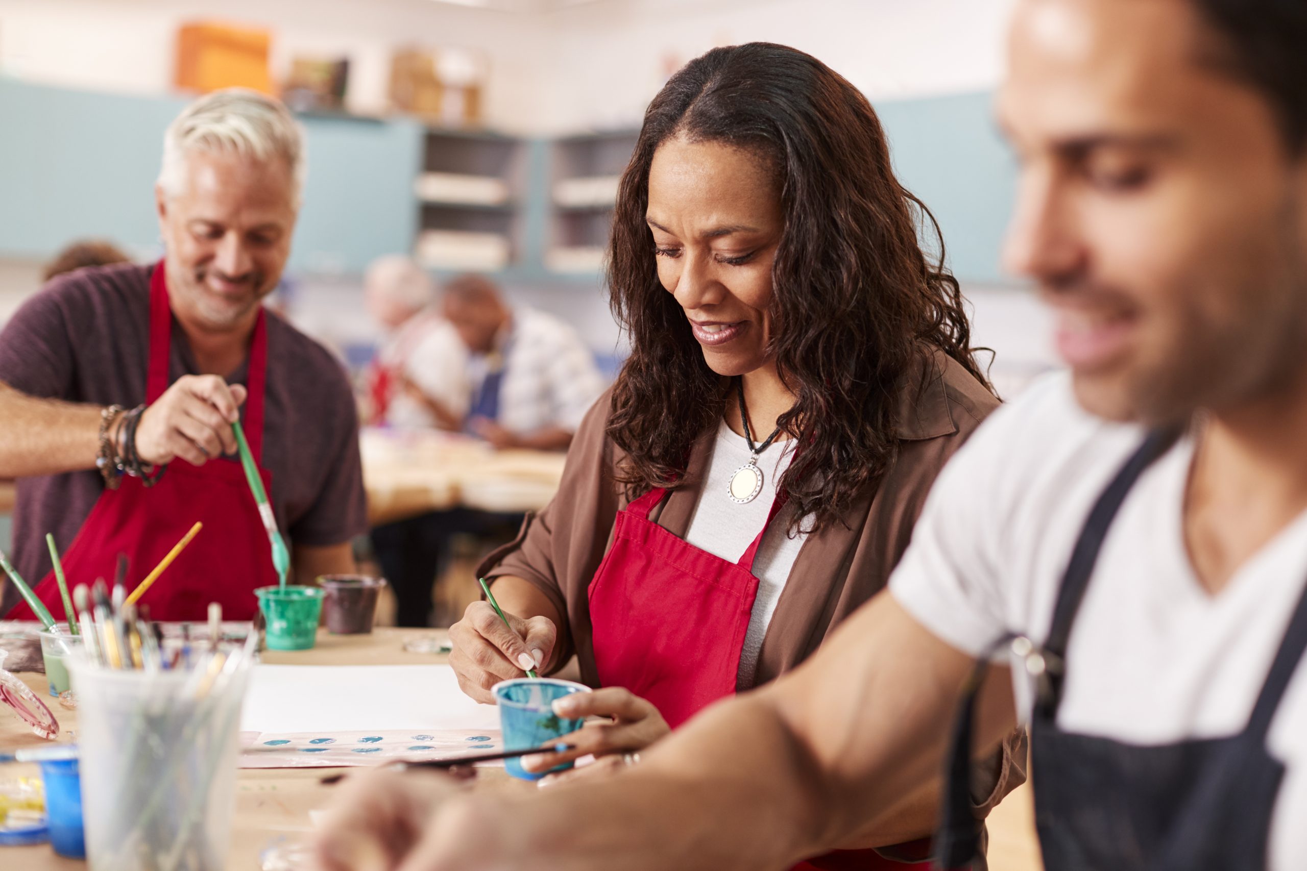 Group Of Mature Adults Attending Art Class In Community Centre